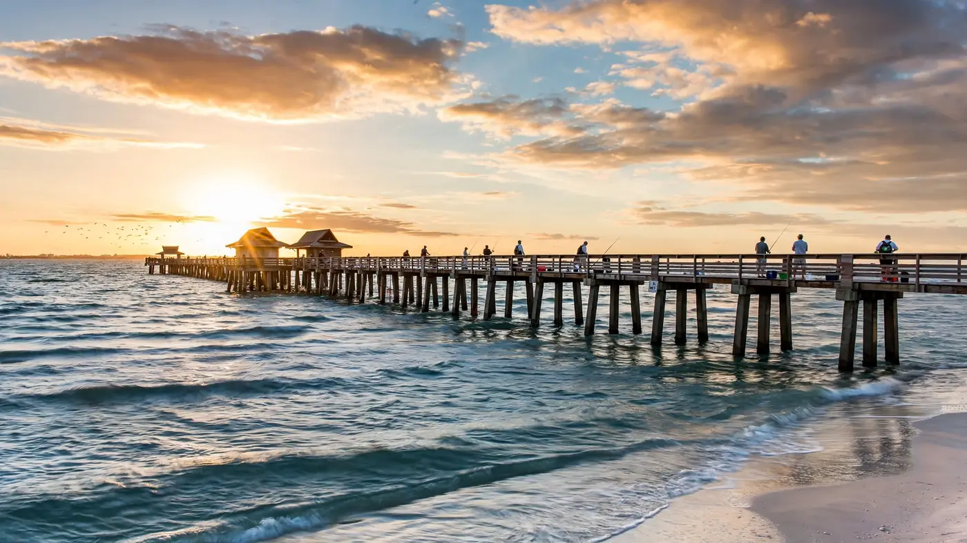 Water damage restoration in Laurel, FL: a fishing pier stretching into the Gulf at sunset with anglers